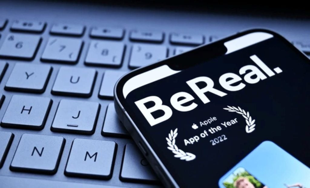 A close-up of a smartphone displaying the BeReal app on a keyboard background, highlighting its authentic social media concept.