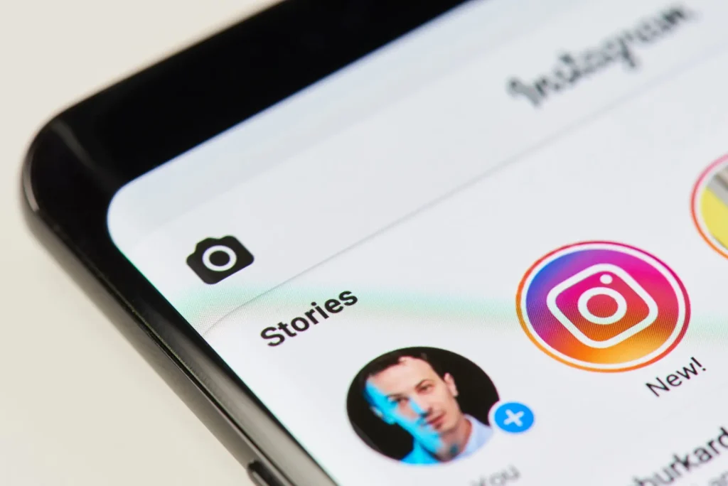 A smartphone screen displaying the Instagram app interface focused on the Stories section with profile icons and the camera symbol.