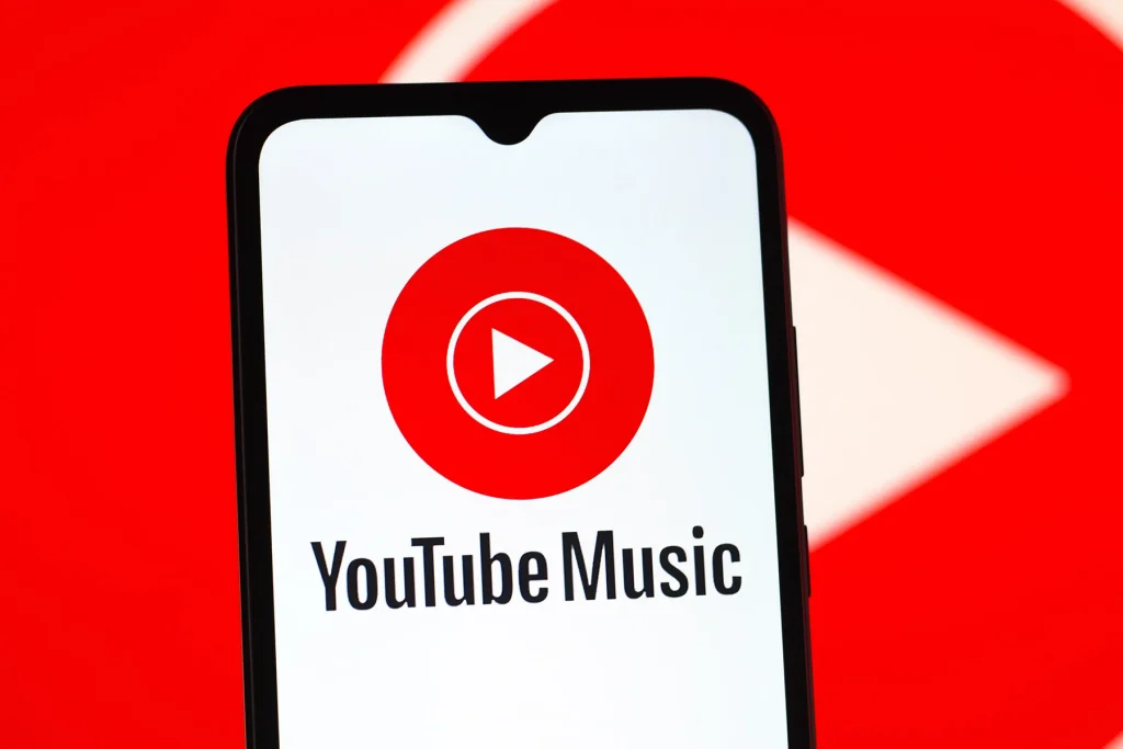 A smartphone screen displaying the YouTube Music app logo with a red play button icon on a bright red background.