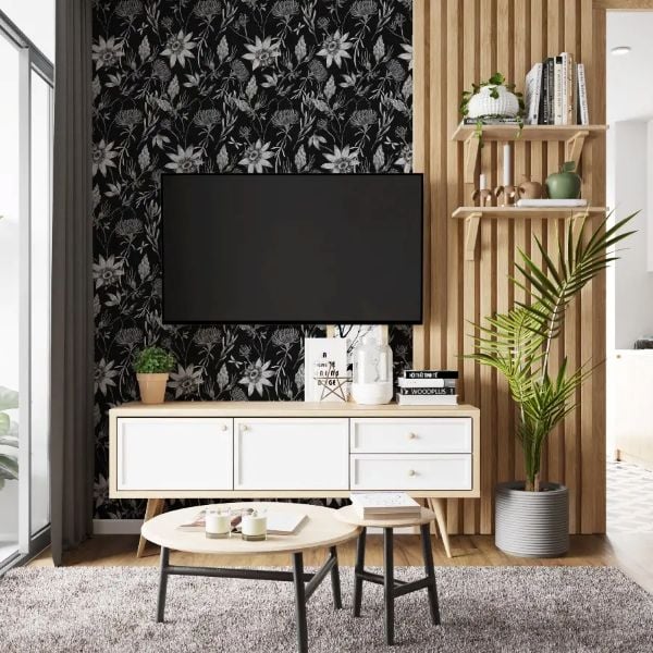 Modern renter-friendly TV wall with black floral wallpaper, wood slat panels, floating shelves, and houseplants.