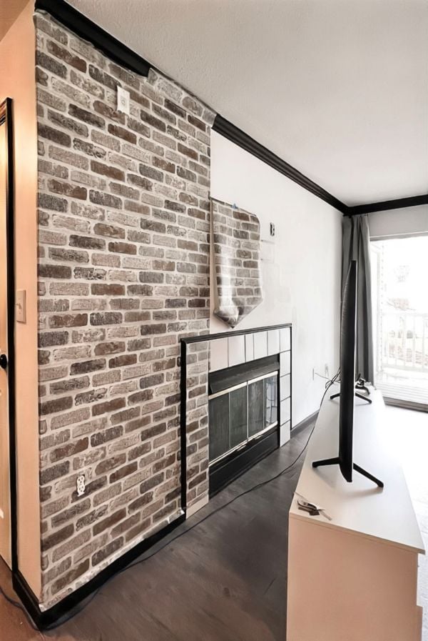 Side view of a fireplace and TV wall covered with white brick peel-and-stick wallpaper in a rental-friendly living room makeover.