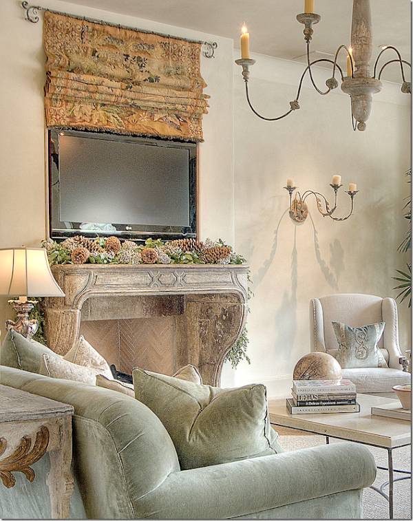 Elegant living room with a TV placed above a mantel, decorated with greenery and a fabric tapestry hanging above it.
