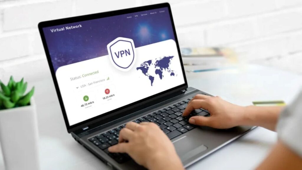 Hands typing on laptop displaying VPN connection interface with world map and connection status visible.