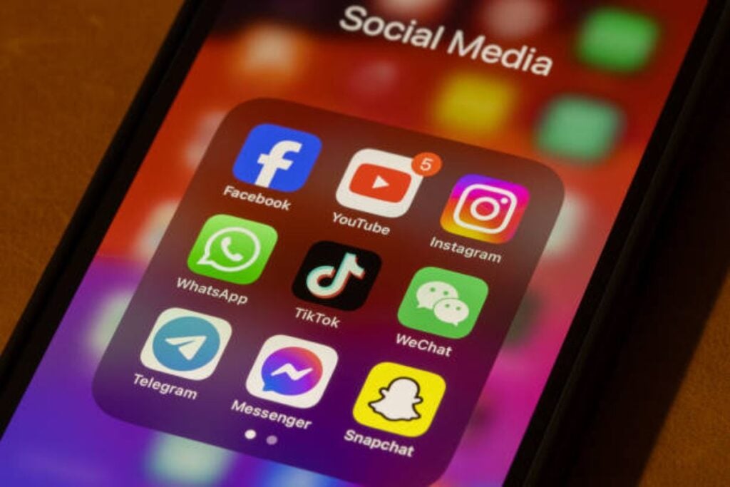 A smartphone screen displaying a folder labeled social media with app icons including Facebook, YouTube, Instagram, WhatsApp, TikTok, WeChat, Telegram, Messenger, and Snapchat.