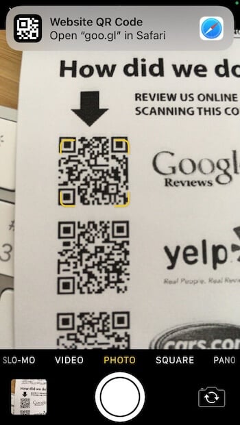 iPhone camera scanning a QR code with a notification prompt to open the detected link in Safari.