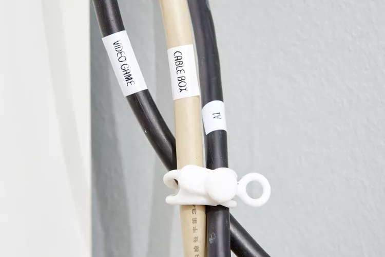 Labeled video game, cable box, and TV cords are grouped together with a white reusable cable tie.