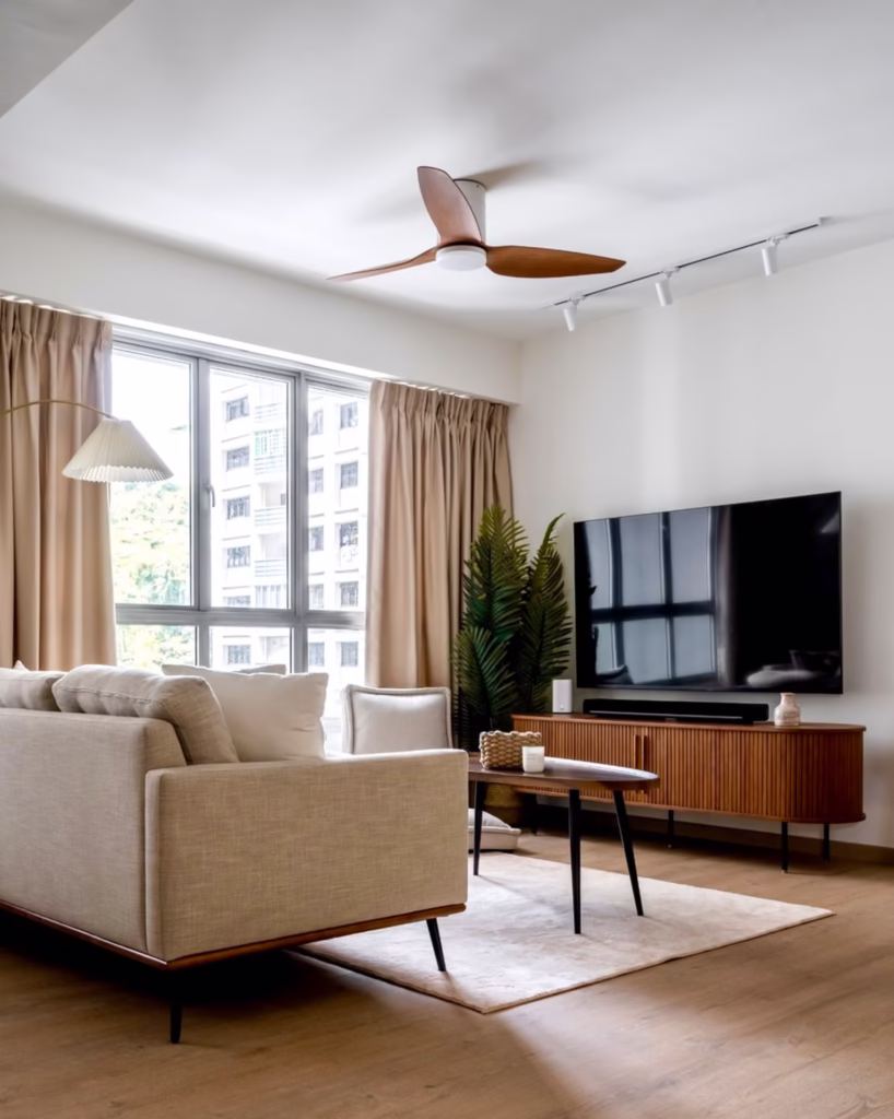 Bright living room with a wall-mounted TV above a wooden media console, using minimal visible cords and a soundbar setup.
